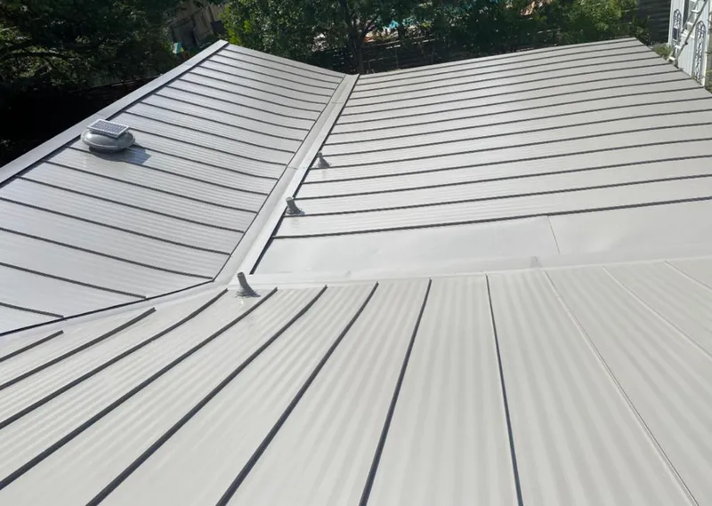 Solar attic fan installed on a metal roof for Roof Ventilation in Grand Haven